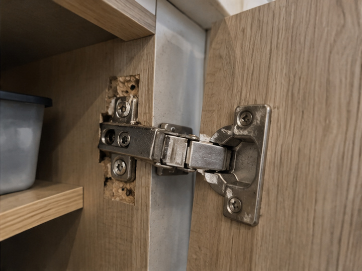 Close-up of damaged cabinet hinge fixing area