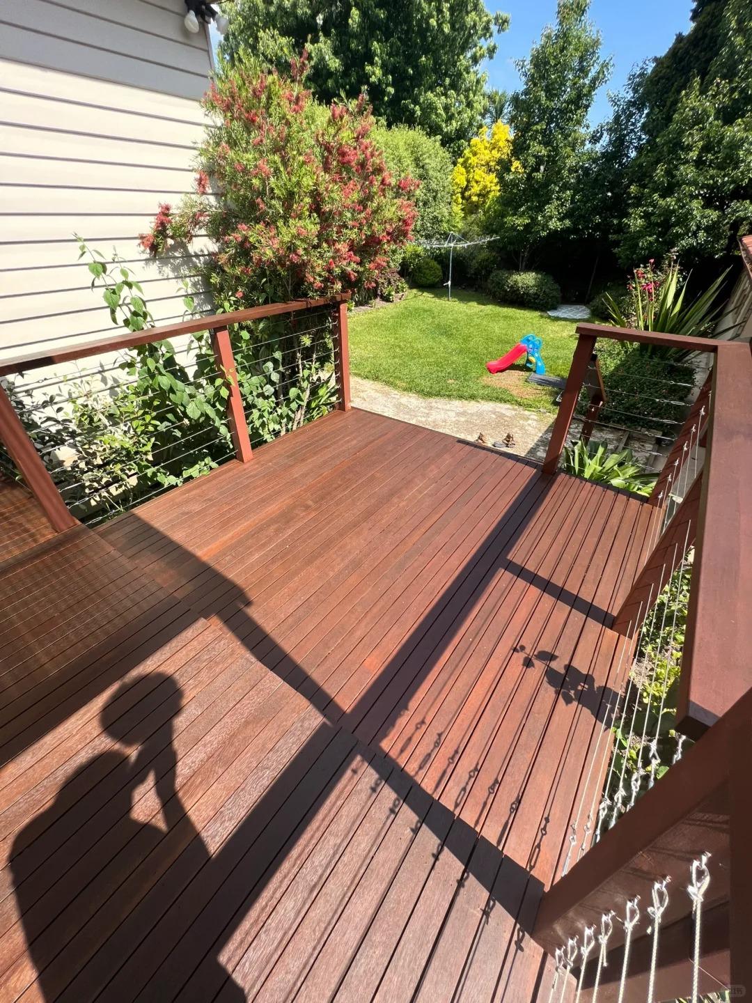 Finished outdoor timber deck with railings and garden setting