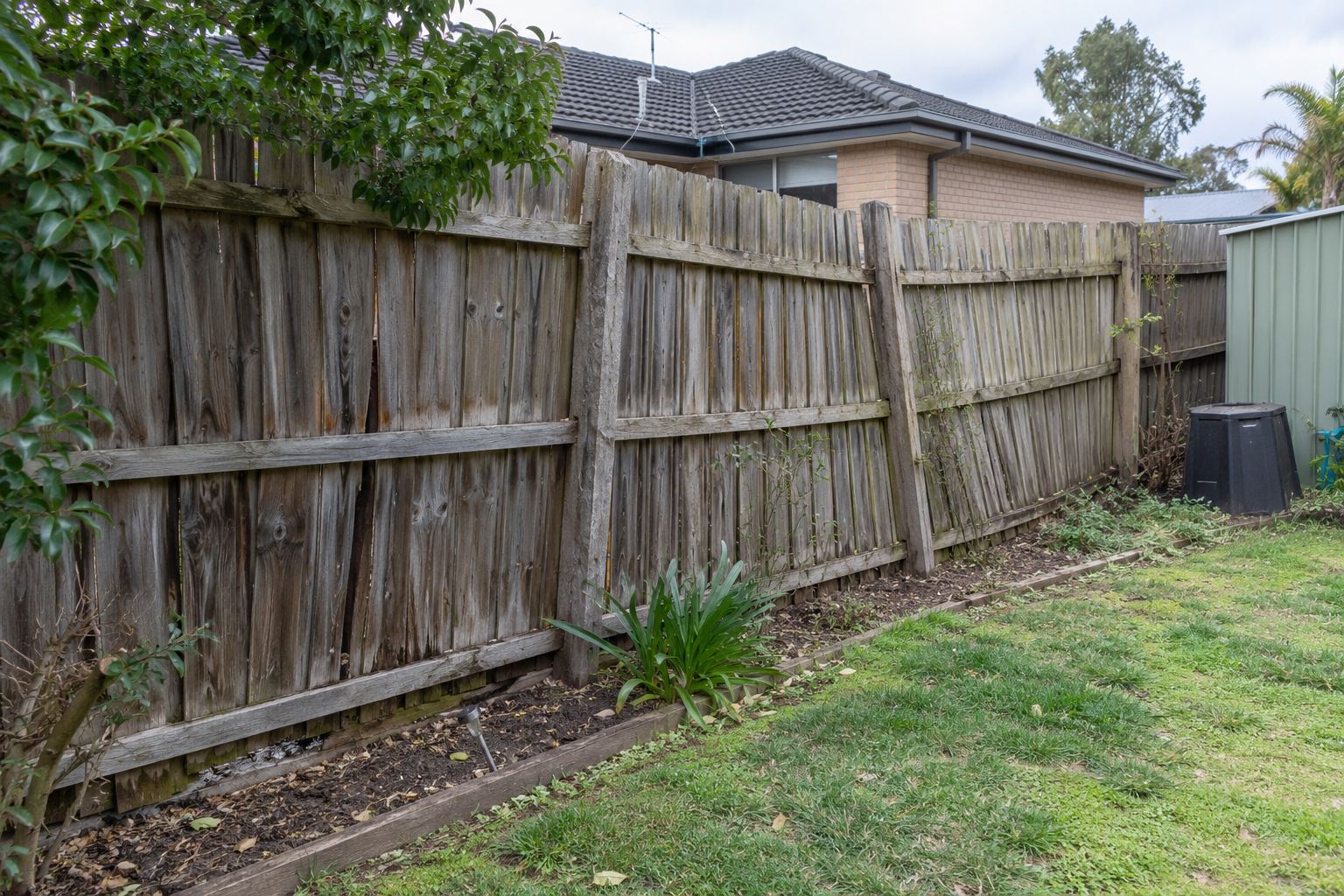 Damaged timber fence before repair