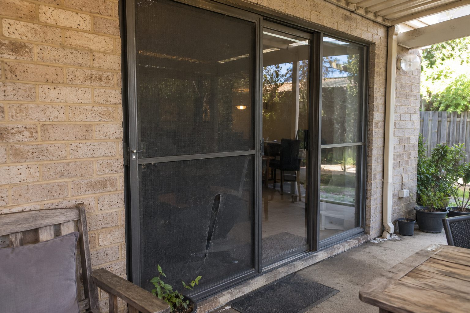 Damaged sliding door flyscreen before repair